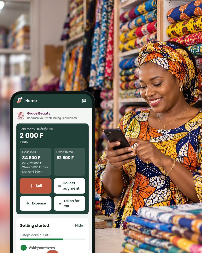 A shop owner in her fabric shop, with the JëndJaay home screen